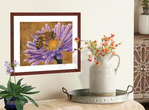 Pastel painting print of a honey bee on a pink flower with gold leaf background with a mahogany frame and 2” white mat hanging in a country kitchen.  Rendered in a realistic style by award winning artist Kathie Miller.