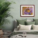 Pastel painting print of a honey bee on a pink flower with gold leaf background with a mahogany frame and 2” white mat hanging in a green bedroom.  Rendered in a realistic style by award winning artist Kathie Miller.