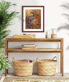 Pastel painting print of a house sparrow on gold leaf with a mahogany frame and 2” white mat hanging in a natural elements entrance hall.  Rendered in a realistic style by award winning artist Kathie Miller.