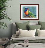 Pastel portrait of a rainbow lorikeet. Print with mahogany frame and a 2” white mat hanging in a soft green bedroom.  Rendered in a contemporary style using bold strokes and bright colors by award winning artist Kathie Miller.