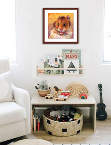 Pastel portrait of a cute hamster print with mahogany frame and a white mat  hanging in a child’s reading nook.  Rendered in a contemporary style using bold strokes and bright colors by award winning artist Kathie Miller.