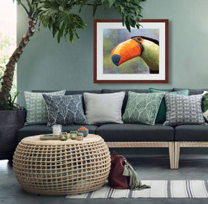 Pastel portrait of a toucan. Print with mahogany frame and a 2” white mat hanging in tropical green living room.  Rendered in a contemporary style using bold strokes and bright colors by award winning artist Kathie Miller.