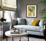 A mock up photo of an elegant sitting room. Hung on the wall is a print of my painting “Ethel-Goose” by award winning artist Kathie Miller. The print has a mahogany frame and white mat. This is a contemporary pastel portrait of a white goose rendered in bold expressive strokes and bright colors. 