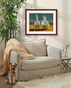Pastel painting of two white ducks walking in the sun framed in mahogany and white mat  in a cozy sitting corner.  Rendered in a contemporary style using bold strokes and bright colors by award winning artist Kathie Miller.