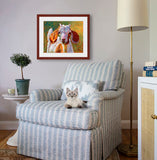 Pastel portrait print of young goat with big floppy ears framed in mahogany and a white mat  in cozy sitting area.  Rendered in a contemporary style using bold strokes and bright colors by award winning artist Kathie Miller.