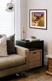 A mock up photo of a small living room corner. Hung on the wall is a print of my painting “Jade-Deer Fawn” by award winning artist Kathie Miller. The print has a mahogany frame and white mat. This is a contemporary pastel portrait of a sea gull rendered in bold expressive strokes and bright colors. 