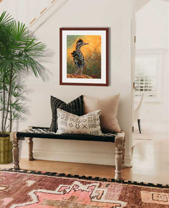Pastel painting print of a greater roadrunner framed in mahogany and a white mat  hanging in a modern southwest style entrance hall.  Rendered in a contemporary style using bold strokes and bright colors by award winning artist Kathie Miller.