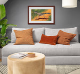 Pastel painting of a greater roadrunner in full run framed in mahogany and a white mat  hanging in a cozy living room.  Rendered in a contemporary style using bold strokes and bright colors by award winning artist Kathie Miller.