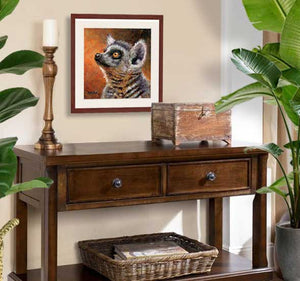 Pastel portrait print of a ring-tail lemur framed in mahogany and a white mat  hanging over a cradenza.  Rendered in a contemporary style using bold strokes and bright colors by award winning artist Kathie Miller.