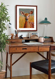 A mock up photo of home office. Hung on the wall is a print of my painting “Lilly – Deer Fawn” by award winning artist Kathie Miller. The print has a mahogany frame and white mat. This is a contemporary pastel portrait of a deer fawn rendered in bold expressive strokes and bright colors. 