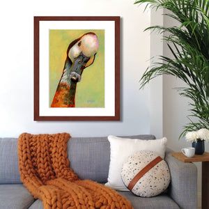 A mock up photo of a elegant living room. Hung on the wall is a print of my painting “Lucy-Goose” by award winning artist Kathie Miller. The print has a mahogany frame and white mat. This is a contemporary pastel portrait of a goose rendered in bold expressive strokes and bright colors. 