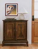 Pastel portrait print of a barn owl framed in mahogany and a white mat  in an entrance hall.  Rendered in a contemporary style using bold strokes and bright colors by award winning artist Kathie Miller.