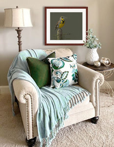 Pastel portrait print of a meadow lark singing in the morning sun with a mahogany frame and 2” white mat hanging cozy living room corner. Rendered in a contemporary style using bold strokes and bright colors by award winning artist Kathie Miller. 