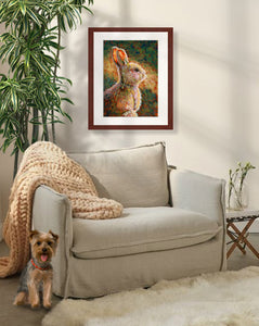 A mock up photo of an elegant sitting area. Hung on the wall is a print of my painting “Mocha - Rabbit” by award winning artist Kathie Miller. The print has a mahogany frame and white mat. This is a contemporary pastel portrait of a rabbit rendered in bold expressive strokes and bright colors. 