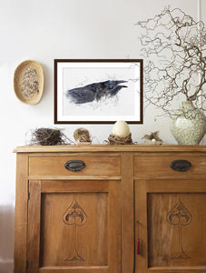 Raven II painting rendered in a contemporary watercolor style hanging over an antique cradenza  by wildlife artist Kathie Miller.  Prints available.