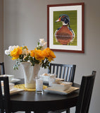 Pastel portrait of a wood duck rendered in a photo realistic style with a mahogany frame hanging in a breakfast nook by award winning artist Kathie Miller.