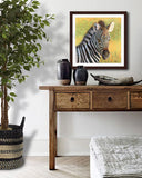 Pastel portrait print of a zebra foal in the morning sun with a dark charcoal frame and 2” white mat hanging over a rustic sidebar. Rendered in a contemporary style using bold strokes and bright colors by award winning artist Kathie Miller. 